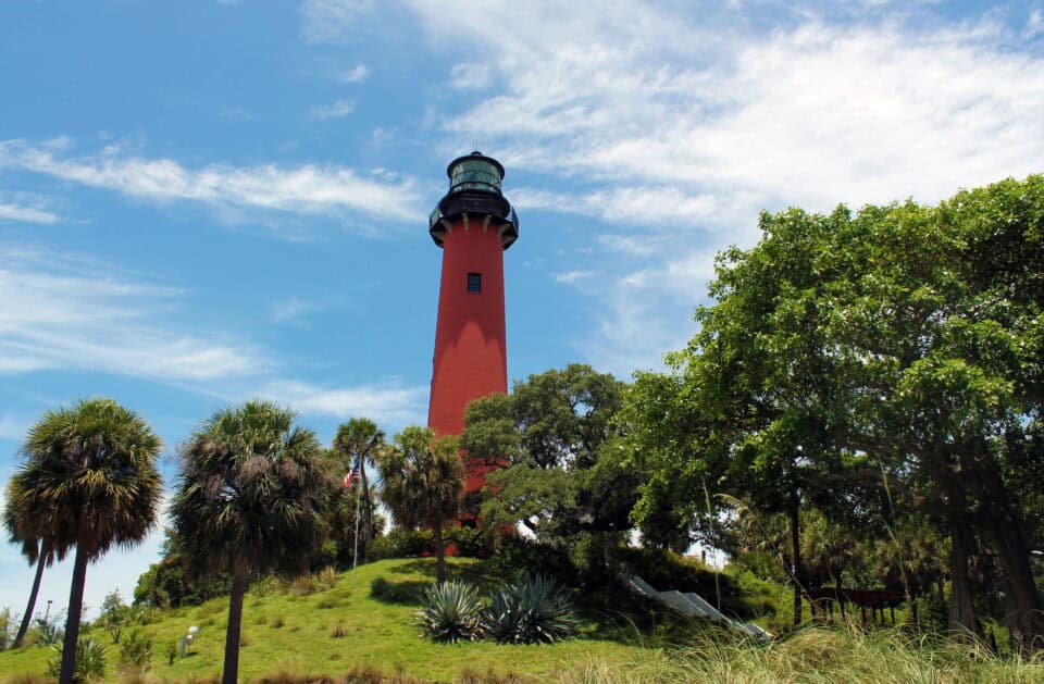 The red Jupiter Inlet Lighthouse against a blue sky in Jupiter, Florida