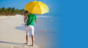 Father-walking-with-daughter-on-a-beach-under-an-umbrella